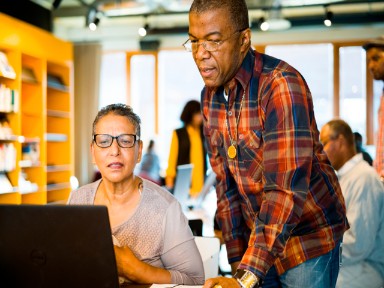 OBA medewerker helpt mevrouw achter een laptop