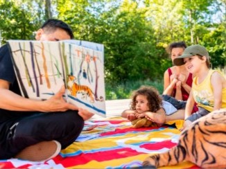 OBA medewerker leest een boek voor aan kinderen